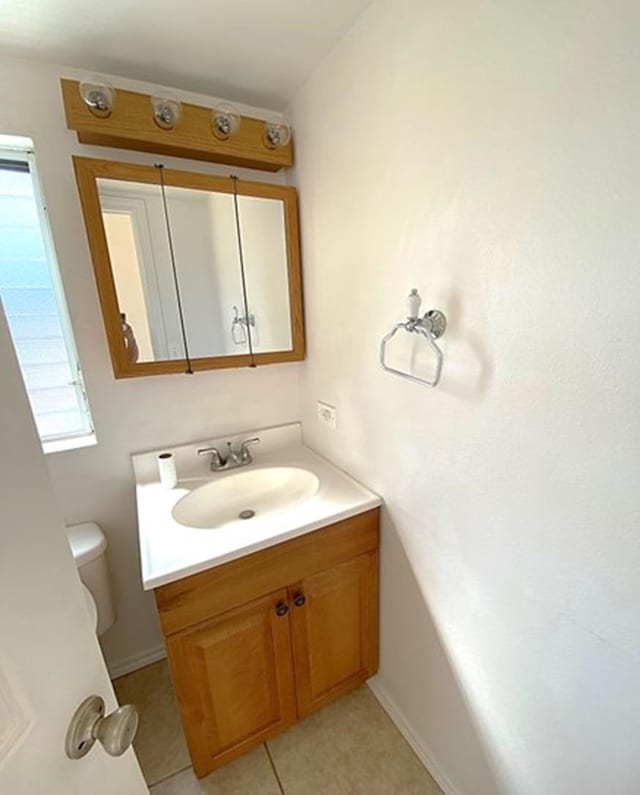 bathroom featuring tile patterned flooring, toilet, and vanity