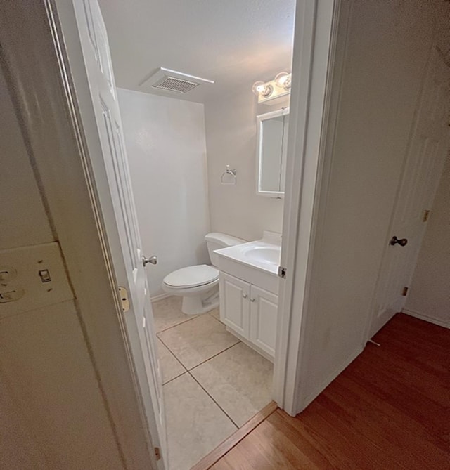 bathroom with vanity, toilet, and hardwood / wood-style floors