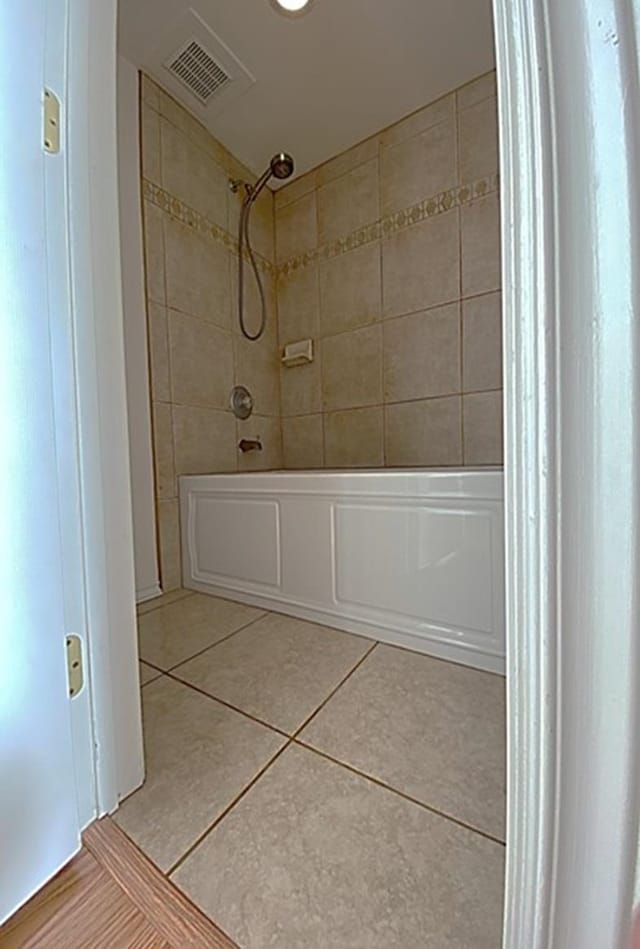 bathroom with tiled shower / bath and tile patterned floors