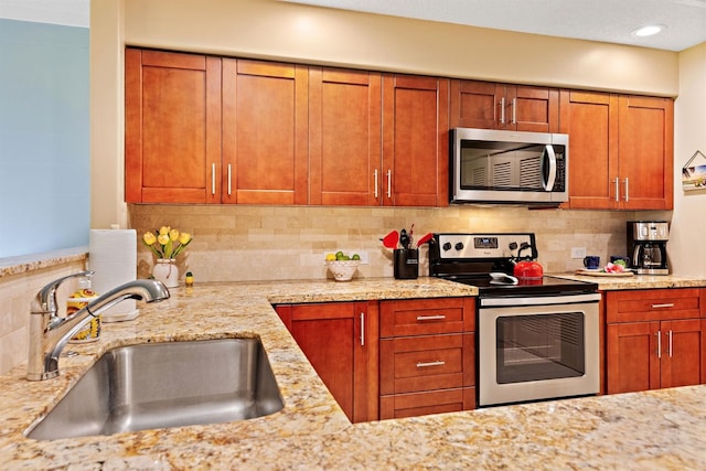 2560 Kekaa Dr Unit F 102, Lahaina, HI 96761 - kitchen with appliances with stainless steel finishes, a sink, decorative backsplash, light stone counters, and brown cabinetry