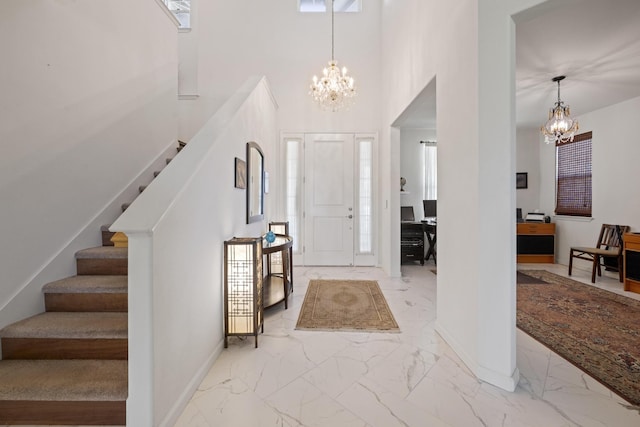 foyer featuring stairway, an inviting chandelier, baseboards, and marble finish floor