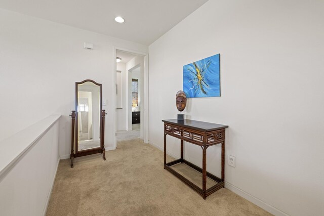 corridor featuring light carpet, baseboards, and recessed lighting