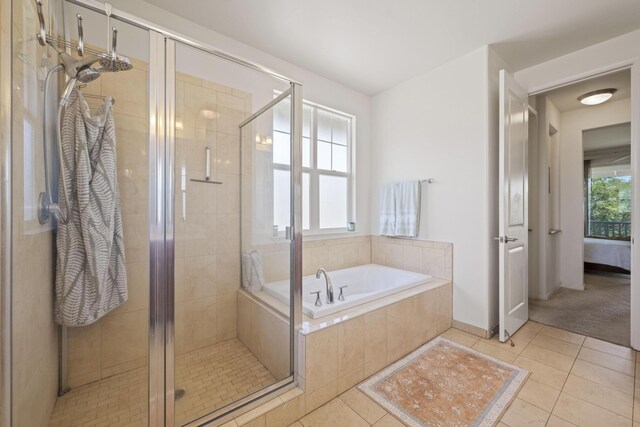 ensuite bathroom featuring a bath, connected bathroom, tile patterned flooring, and a stall shower