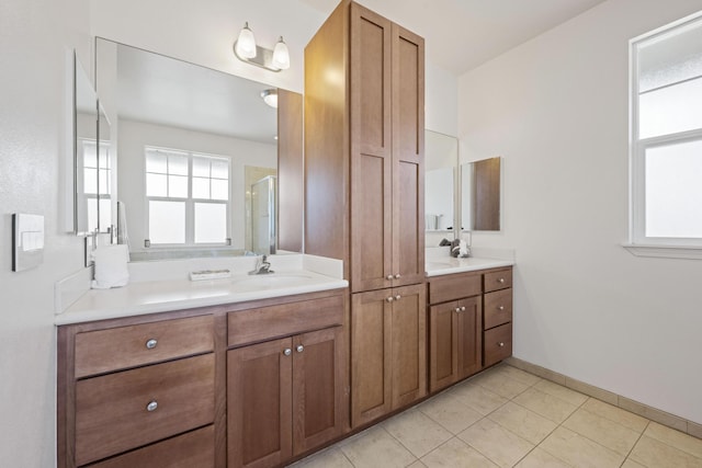 full bathroom with tile patterned floors, vanity, baseboards, and a shower stall