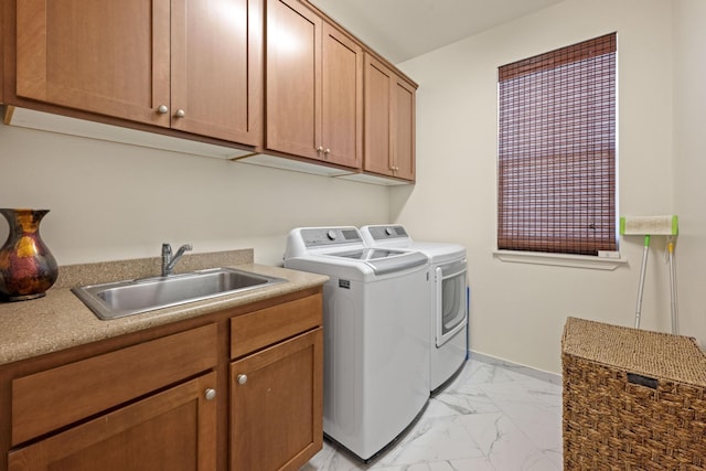 laundry area featuring cabinet space, washer and clothes dryer, marble finish floor, and a sink