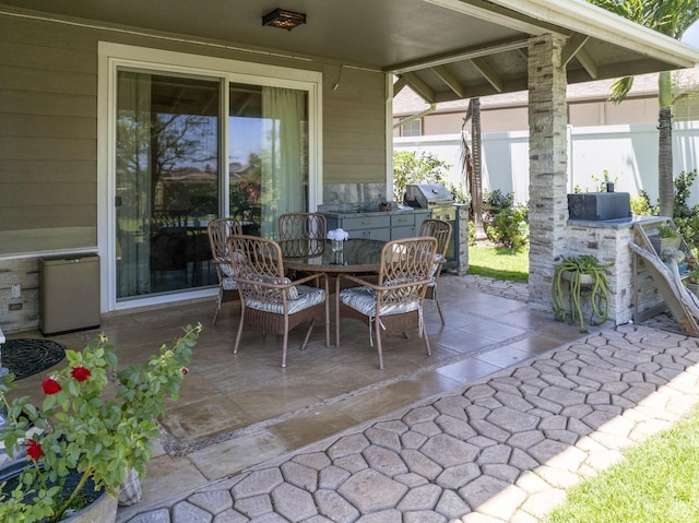 view of patio with a grill, fence, and outdoor dining space