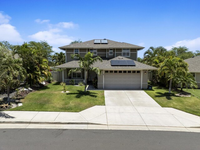 view of front of home featuring roof mounted solar panels, an attached garage, a front lawn, and driveway