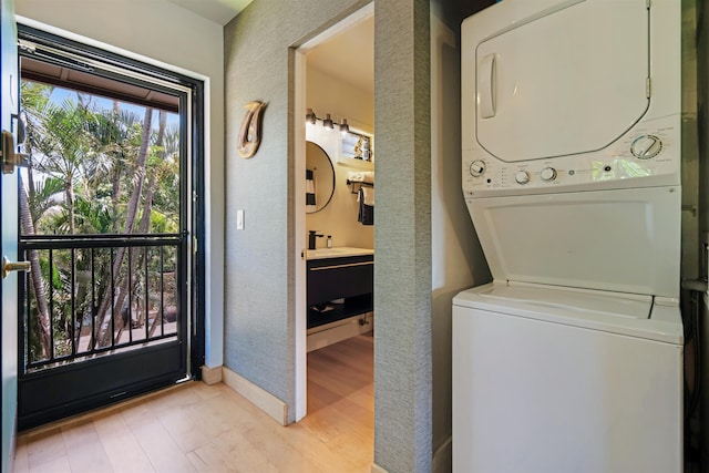3788 Lower Honoapiilani Rd Unit E212, Lahaina, HI 96761 - laundry room featuring stacked washer / drying machine, light wood-type flooring, and a textured wall