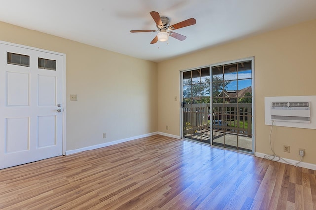 empty room featuring baseboards, a ceiling fan, light wood finished floors, and a wall mounted AC