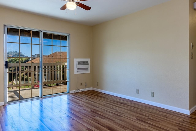 spare room with hardwood / wood-style floors, a wall mounted AC, and ceiling fan