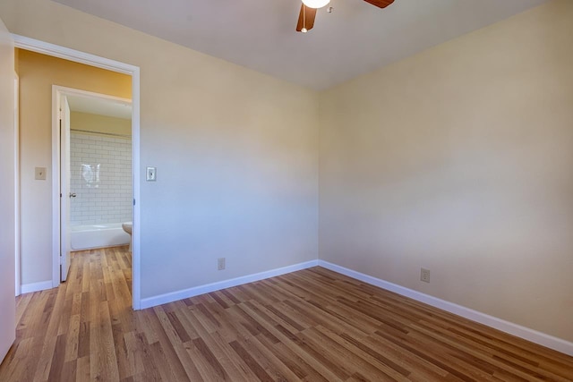 empty room featuring baseboards, wood finished floors, and ceiling fan