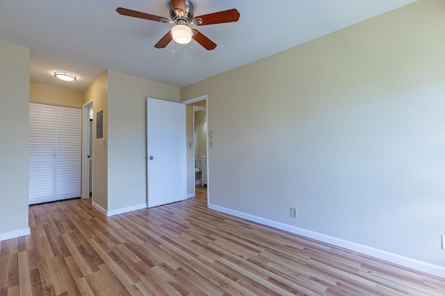 unfurnished bedroom with a closet, a ceiling fan, baseboards, and light wood-type flooring