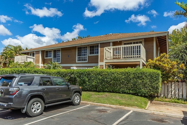 view of front of house featuring uncovered parking and a balcony