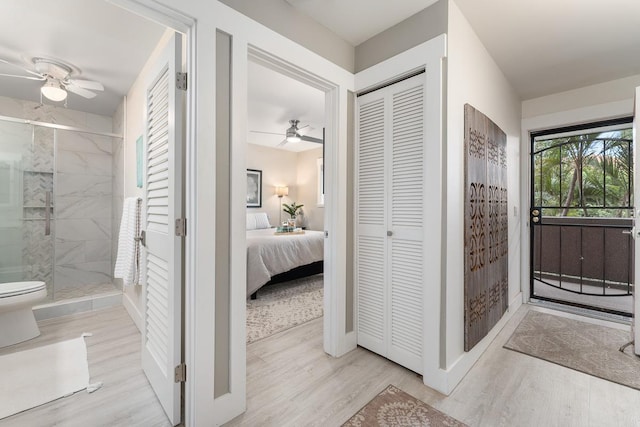 full bath with a stall shower, ceiling fan, wood finished floors, and a closet