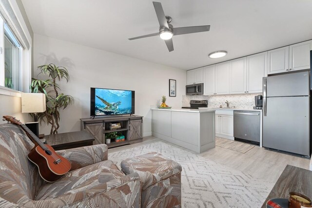 living area with light wood finished floors and a ceiling fan