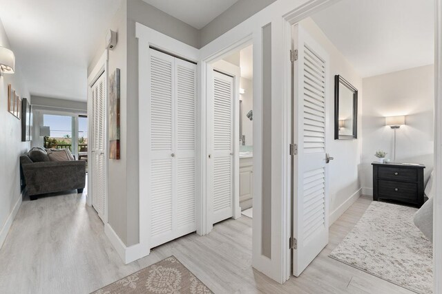 hallway featuring light wood-style flooring and baseboards
