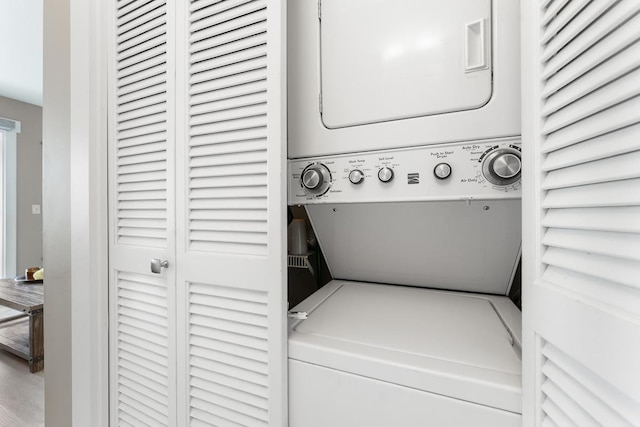 clothes washing area featuring stacked washer / dryer and laundry area