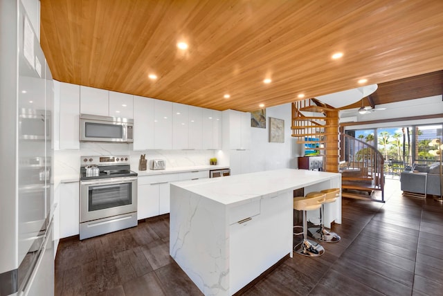 kitchen featuring wooden ceiling, stainless steel appliances, and white cabinetry