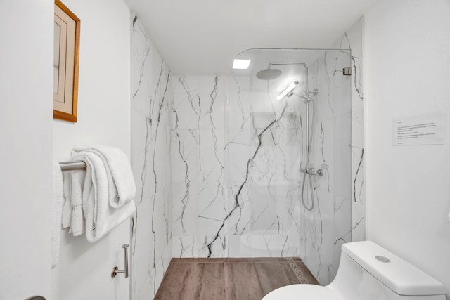 bathroom with toilet and a tile shower