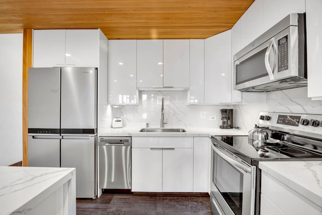 kitchen featuring light stone countertops, white cabinets, stainless steel appliances, sink, and wooden ceiling