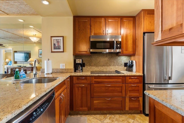 kitchen with decorative backsplash, light stone countertops, sink, and appliances with stainless steel finishes