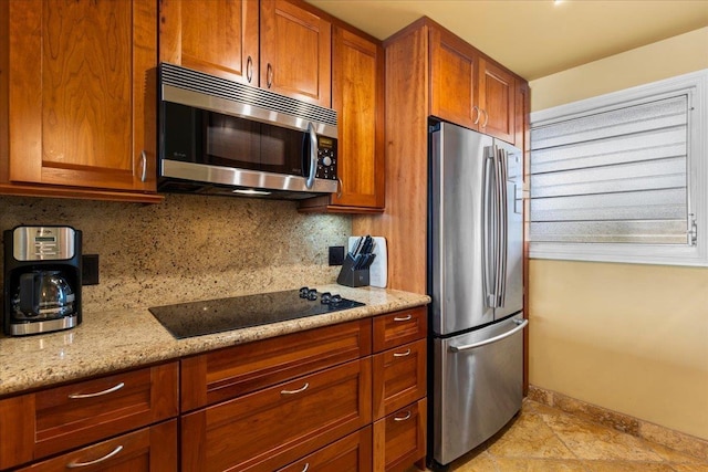 kitchen featuring decorative backsplash, light stone countertops, and appliances with stainless steel finishes