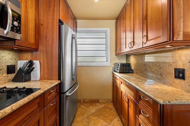 kitchen featuring light stone countertops, appliances with stainless steel finishes, and backsplash