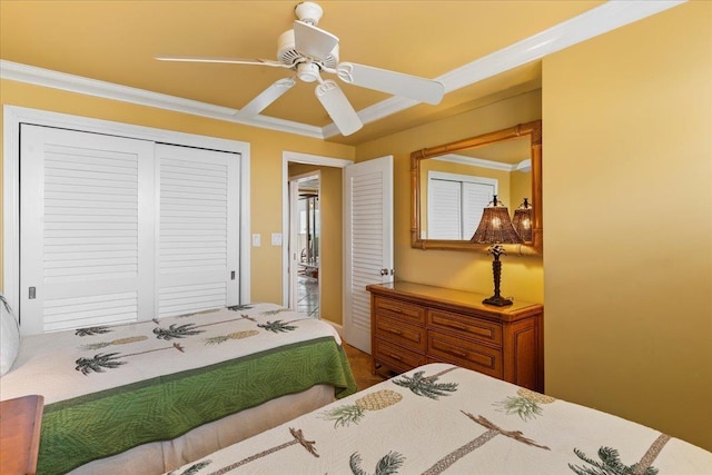 bedroom with ceiling fan, crown molding, and a closet