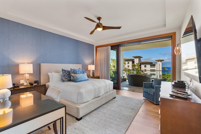 bedroom featuring access to exterior, a ceiling fan, light wood finished floors, and wallpapered walls