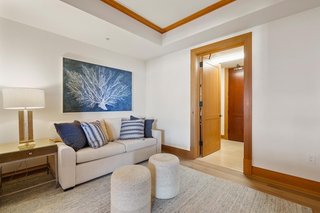 living room featuring ornamental molding, light wood finished floors, and baseboards