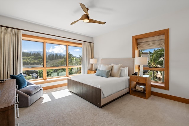 bedroom with light carpet, ceiling fan, and baseboards