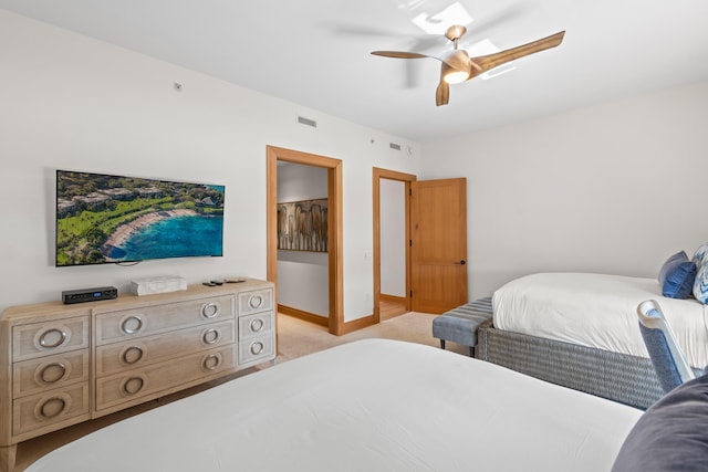 bedroom featuring light carpet, a ceiling fan, visible vents, and baseboards