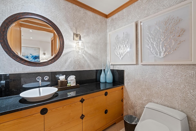 half bath featuring toilet, crown molding, and vanity