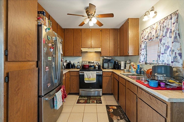 kitchen featuring appliances with stainless steel finishes, ceiling fan, light countertops, under cabinet range hood, and brown cabinetry