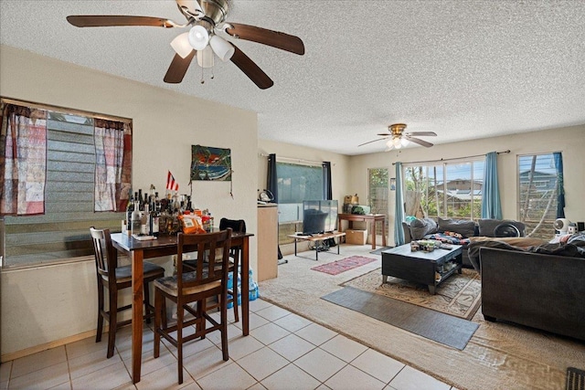 living area with light tile patterned flooring, a ceiling fan, and a textured ceiling