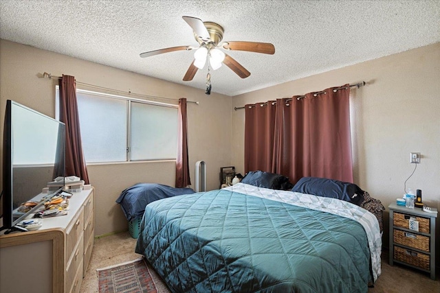 bedroom with a ceiling fan, a textured ceiling, and carpet flooring