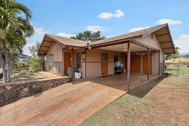 exterior space featuring fence, roof with shingles, a gate, and concrete driveway