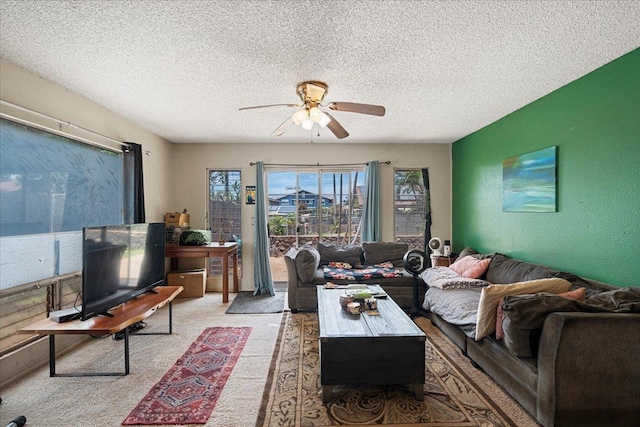 carpeted living area featuring a ceiling fan, a wealth of natural light, and a textured ceiling
