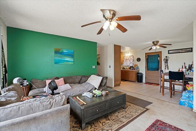 carpeted living room featuring tile patterned flooring, a ceiling fan, and a textured ceiling