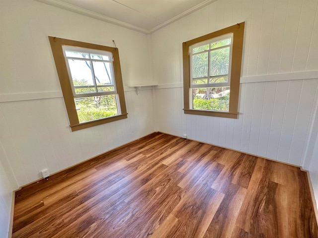 spare room with crown molding, hardwood / wood-style flooring, and a healthy amount of sunlight