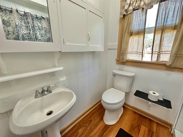 bathroom with toilet, plenty of natural light, and wood-type flooring