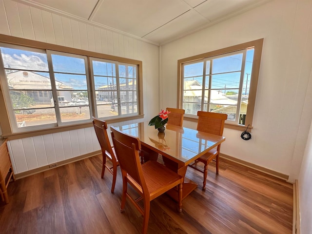 dining space with dark hardwood / wood-style flooring, ornamental molding, and plenty of natural light