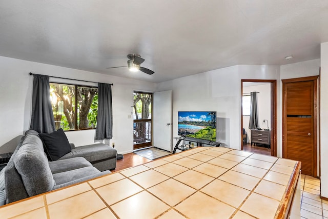 living room with ceiling fan and light tile patterned flooring