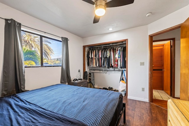 bedroom with a closet, ceiling fan, and dark hardwood / wood-style floors