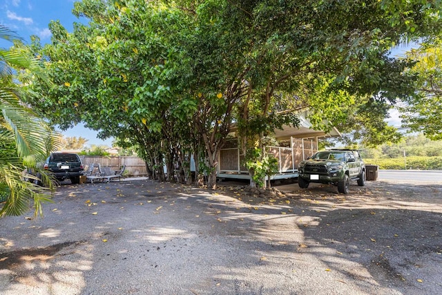 view of property hidden behind natural elements featuring a deck