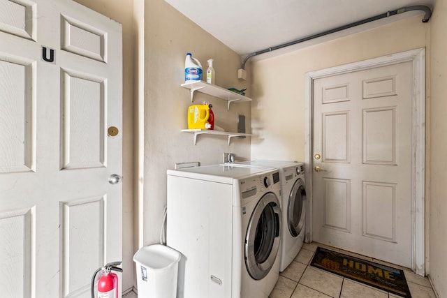 clothes washing area with separate washer and dryer and light tile patterned floors