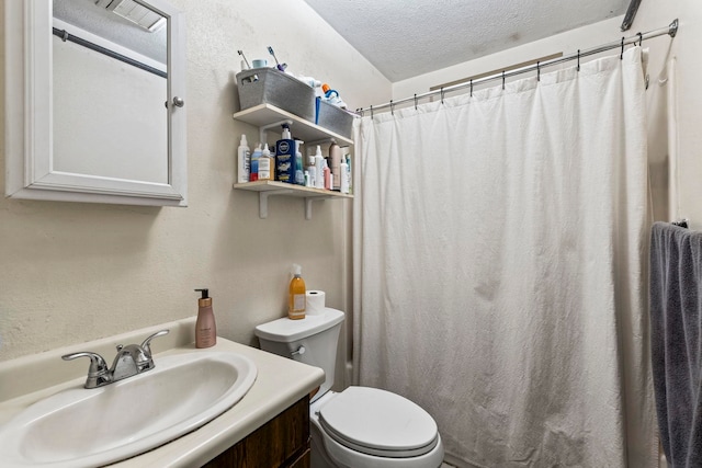 bathroom with vanity, toilet, and a textured ceiling