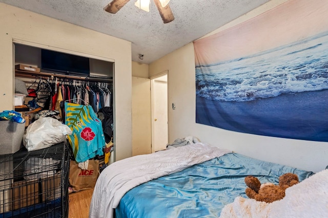 bedroom with a textured ceiling, a closet, ceiling fan, and hardwood / wood-style flooring