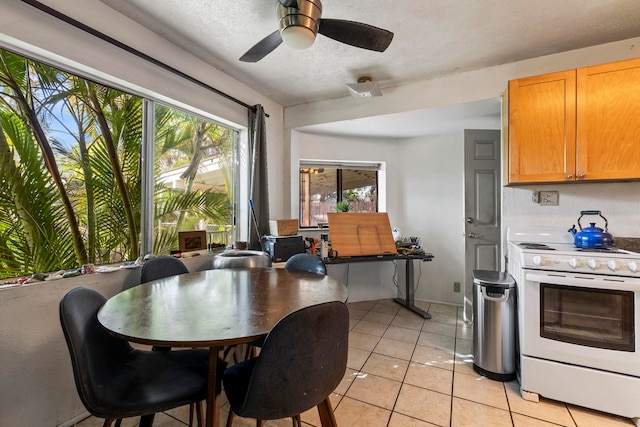 tiled dining area featuring ceiling fan and a textured ceiling