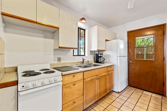 kitchen featuring sink, light tile patterned floors, and white appliances